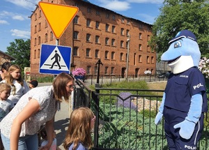 dzieci  i maskota stoją przy  znaku