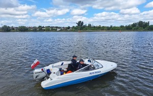 policjanci pływający łodzą po jeziorze