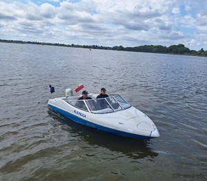 policjanci płyną łodzią policyjną