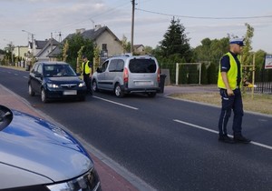 policjant sprowadza trzeźwość kierowcy granatowej osobówki