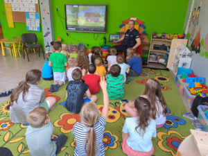 policjant  i dzieci siedzą na dywanie