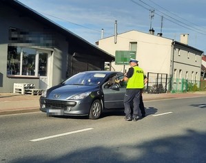 policjant sprawdza trzeźwość kierowcy osobówki