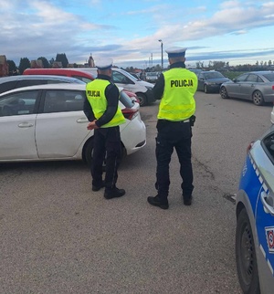 Policjanci drogówki obserwują przemieszczające się samochody i sposób ich parkowania.