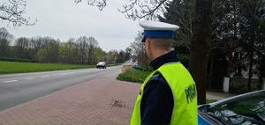 Policjant ruchu drogowego obserwuje nadjeżdżające pojazdy