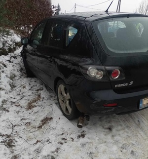 Pojazd marki Mazda, który stoi na skraju drogi pokrytej śniegiem.