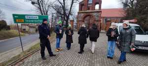 Dzielnicowy rozmawia z wolontariuszami zebranymi w rejonie kościoła św. Marcina w Żninie