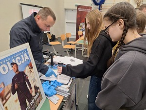 technik kryminalistyki  wspólnie z dziewczynami zabezpiecza ślady daktyloskopijne