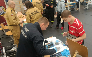 technik wraz z młodym chłopcem zabezpiecza ślady daktyloskopijne
