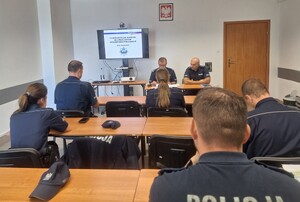policjanci siedzą w ławkach, oczekują na test