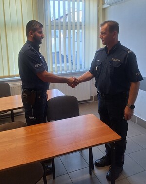 dwóch umundurowanych policjantów podaje sobie rękę