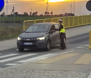 policjantka bada stan trzeźwości kierującego pojazdem osobowy