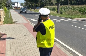 policjant ruchu drogowego dokonuje  pomiaru  prędkości